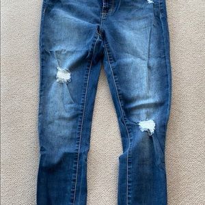 Faded blue jeans, lightly destroyed denim